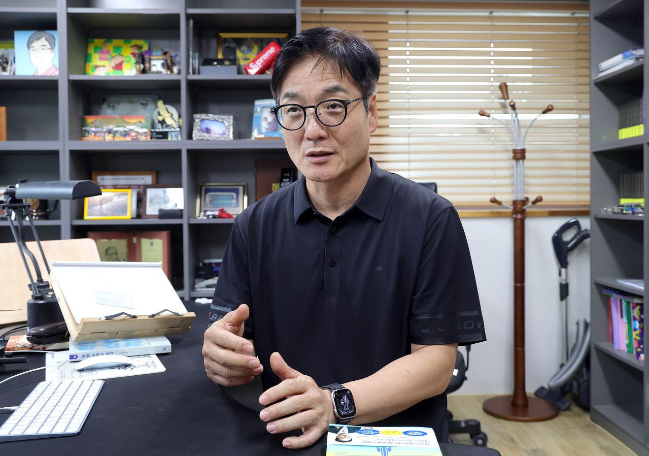 연구실 책상 앞에 앉아 손짓하며 인터뷰에 답하는 신종호 서울대 교육학과 교수